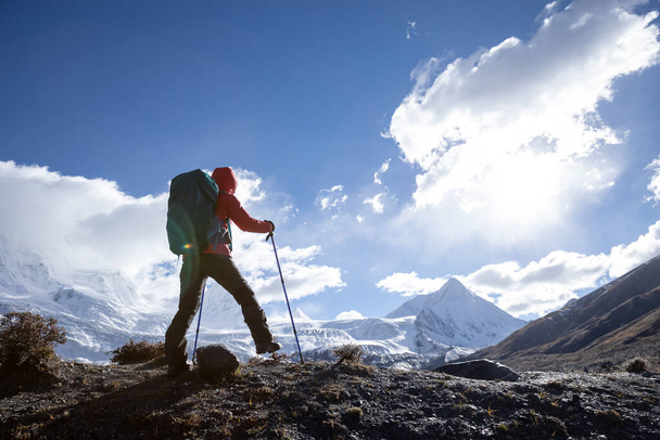 Successful woman backpacker hiking in winter high altitude mountains - Fotografie, Obrázek