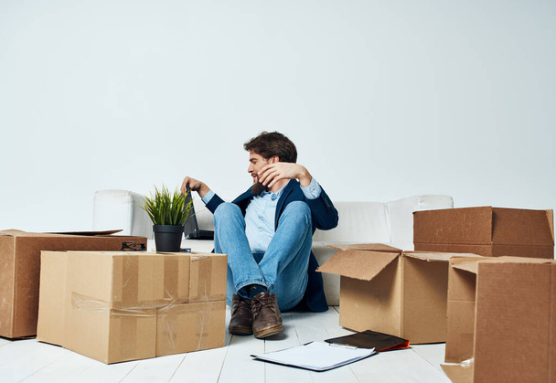 Man sitting on the floor with boxes of stuff moving to office unpacking lifestyle - Φωτογραφία, εικόνα