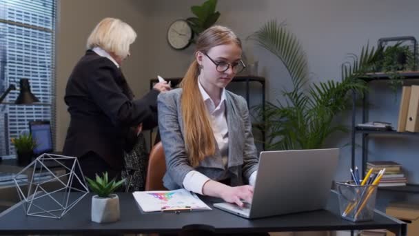 astuta joven mujer de negocios frotándose las manos maquinando malvado truco plan de broma en mente en el interior de la oficina - Metraje, vídeo