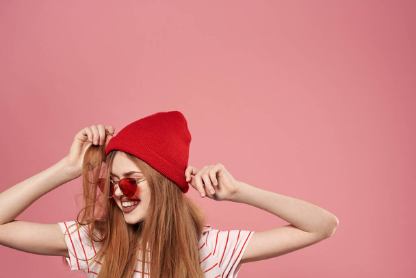 lunettes de soleil femme à la mode et chapeau rouge studio rose fond mode - Photo, image