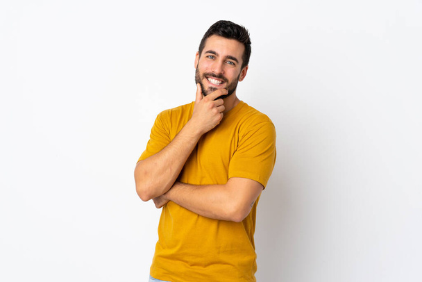 Fiatal jóképű férfi szakállal elszigetelt fehér háttér boldog és mosolygós - Fotó, kép
