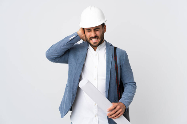 Young architect man with helmet and holding blueprints isolated on white background frustrated and covering ears - Foto, Bild
