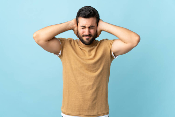 Young handsome man with beard over isolated background frustrated and covering ears - Zdjęcie, obraz