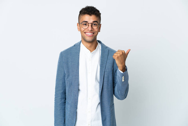 Νεαρός επιχειρηματίας Βραζιλιάνος απομονωμένος σε λευκό φόντο που δείχνει προς τα πλάγια για να παρουσιάσει ένα προϊόν - Φωτογραφία, εικόνα