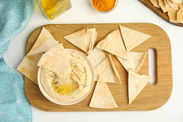 Delicious hummus with pita chips on white wooden table, flat lay - Zdjęcie, obraz