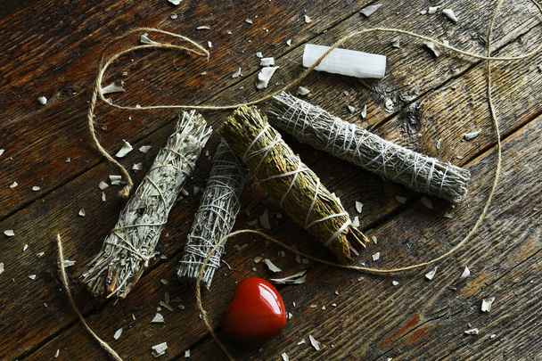 A close up image of white sage smudge bundles with selenite and red jasper crystals.  - Foto, afbeelding