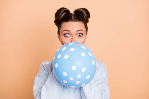Photo of optimistic nice brunette lady blow balloon wear blue sweater isolated on pastel beige color background - Zdjęcie, obraz