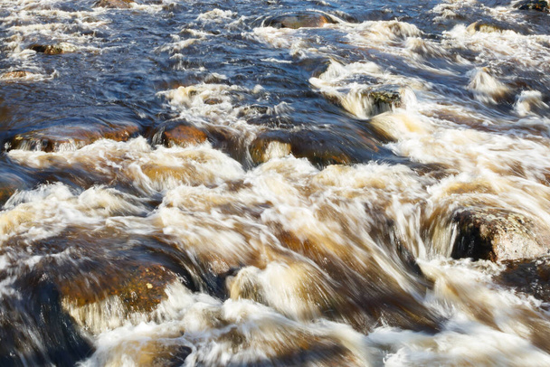 Long exposure photo. Rough river Jokelanjoki and stones in water, Kouvola, Finland. - Photo, Image