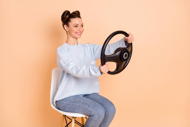 Profile photo of optimistic cool brunette lady sit drive wear sweater jeans isolated on pastel beige color background - Photo, image