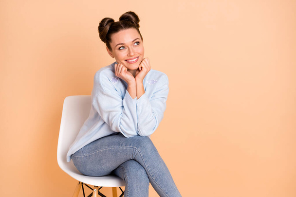 Photo of optimistic cool brunette lady sit look empty space hands fists wear sweater jeans isolated on pastel beige color background - 写真・画像