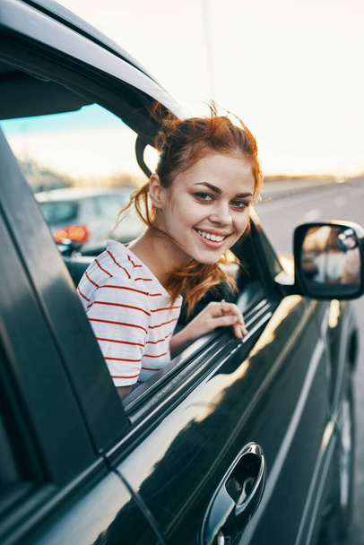woman in striped t-shirt red hair car window salon model - Foto, Imagem