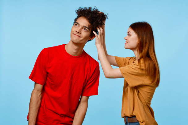 Alegre chico y chica en multicolor camisetas emociones alegría de la comunicación - Foto, imagen