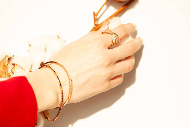 Um lindo anel de ouro e uma pulseira de ouro em um close-up menina. - Foto, Imagem