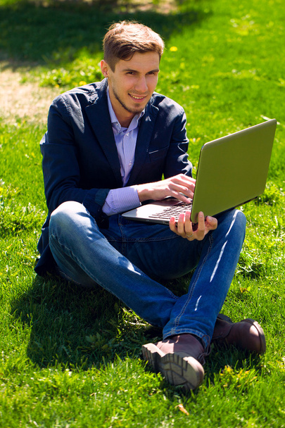man on the grass. fashion style. talking skype. outdoor - Photo, Image