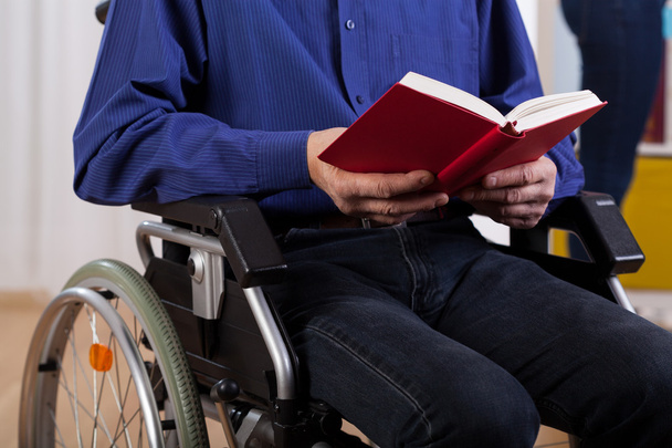 Disabled man reading book - Foto, afbeelding