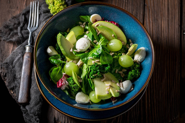 Healthy kale salad made of avocado, lettuce and fruits. Spring healthy food. - Фото, изображение