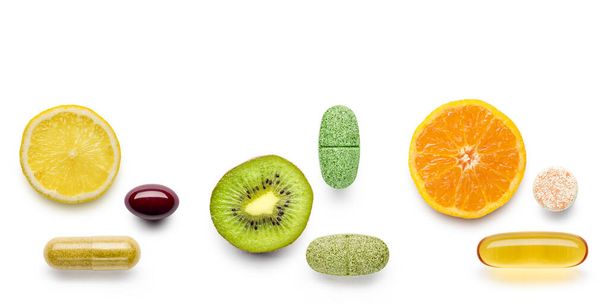 diverses pilules de suppléments vitaminiques avec des agrumes sur fond blanc - Photo, image