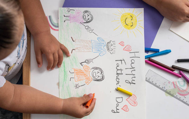 Detalle plano de las manos de dos niñas haciendo a mano algunos dibujos y tarjetas para su padre para el Día del Padre. - Foto, imagen