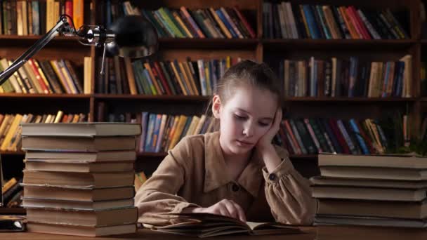 Joven dama de chaqueta marrón lee materiales de entrenamiento en libro - Imágenes, Vídeo