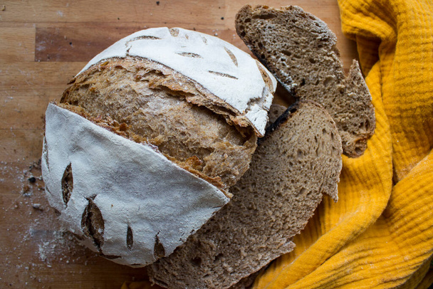 Pane croccante su un asciugamano da cucina giallo. Foto vista dall'alto di pane fresco lievito naturale. - Foto, immagini