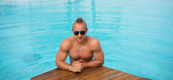 homem muscular posando na piscina
 - Foto, Imagem