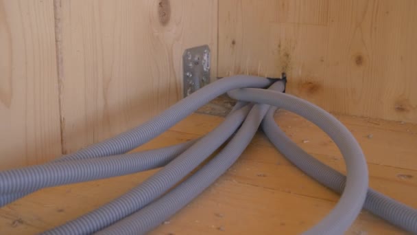 CLOSE UP: Internetleitungen kommen aus einem Loch in der Holzwand und durchqueren einen Raum. - Filmmaterial, Video
