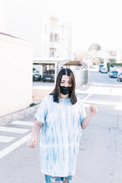 Chica adolescente en una camisa de tinte de corbata caminando por la calle - Foto, Imagen