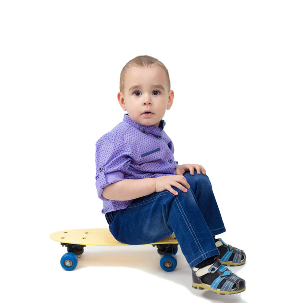 Sad child sitting on a skateboard tired and sleepy. - Foto, Bild