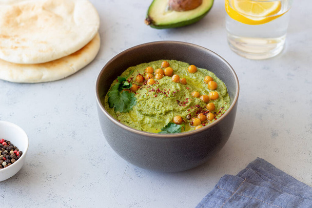 Avocado hummus in a gray bowl. Healthy eating. Vegetarian food - Photo, image