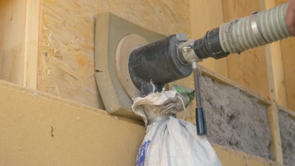 ZAMKNIJ SIĘ: Budowniczy używa dmuchawy do izolowania ściany drewnianej papierem z recyklingu. - Materiał filmowy, wideo
