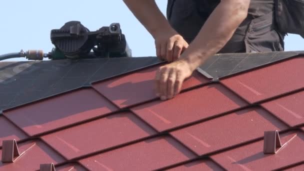 CLOSE UP: Unrecognizable roofer lays aluminium tiles with the help of a nail gun - Footage, Video