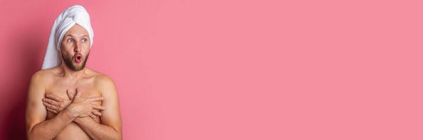 Несподівано голий молодий чоловік із рушником на голові прикривав груди руками на рожевому тлі. Банер - Фото, зображення