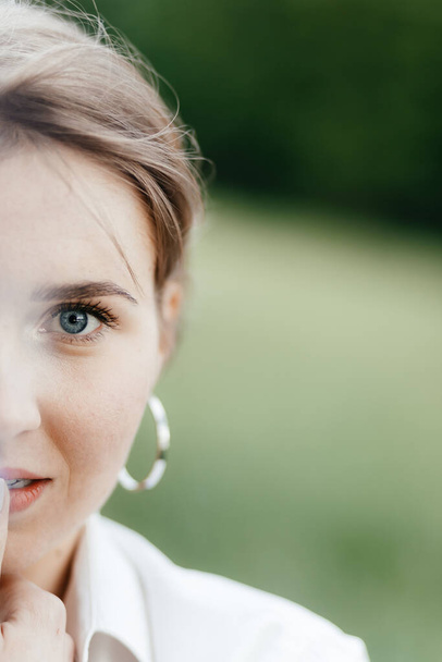 Half face close up of young beautiful smiling girl with round big earrings. Place for your text. High quality photo - Fotoğraf, Görsel