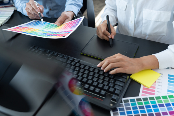 zespół projektantów graficznych pracujący nad projektowaniem stron internetowych przy użyciu kolorowych szablonów do edycji grafiki przy użyciu tabletu i rysika przy biurku w biurze kreatywnym. - Zdjęcie, obraz
