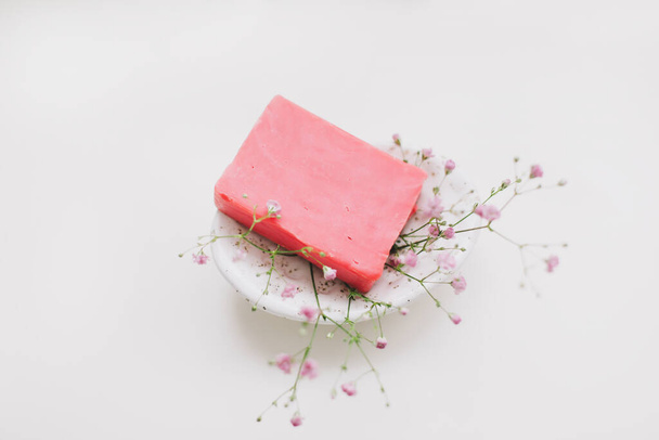 Natural handmade soap bar with ceramic soap dish and flowers, spa organic soap, sustainable lifestyle - 写真・画像