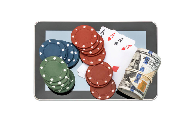 Pokerchips mit Spielkarten und Geld auf dem Tablet-PC. Isoliert auf weiß. Ansicht von oben. - Foto, Bild