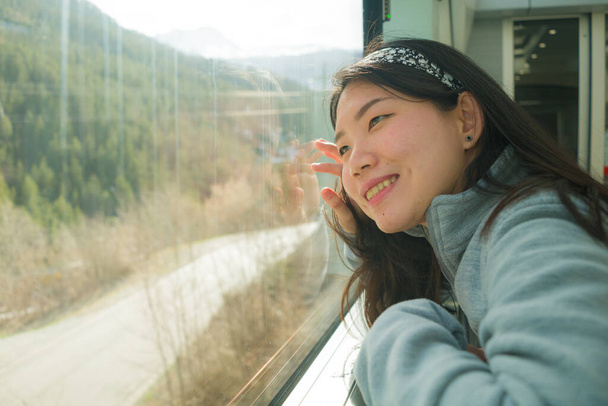 train travel getaway - lifestyle portrait of young happy and beautiful Asian Japanese woman traveling on railway looking through window relaxed and cheerful - Fotografie, Obrázek