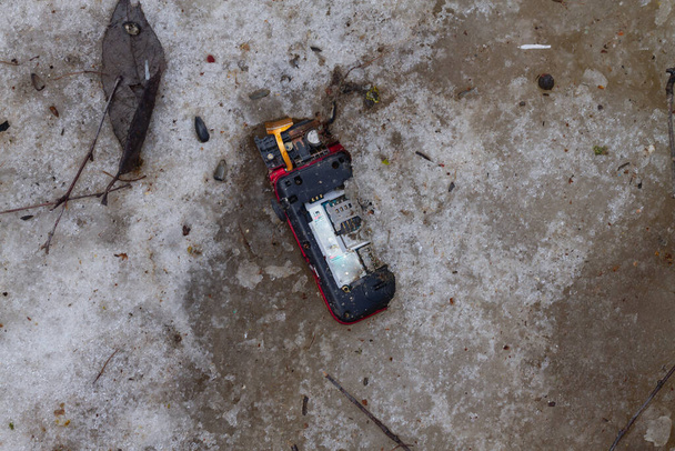 Lost broken cell phone melted in spring from snow. - Foto, Imagem