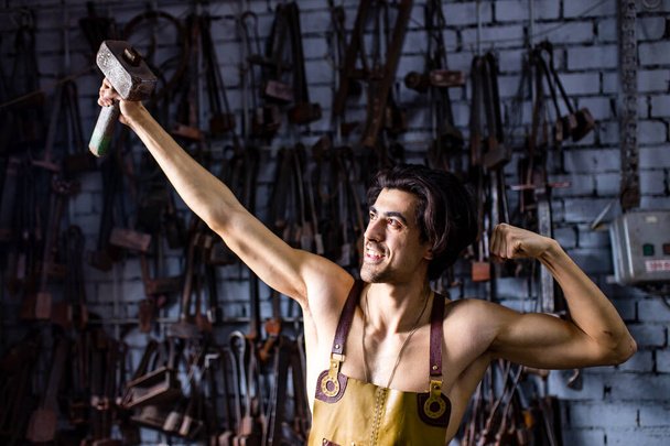 italian brunette man blacksmith working in the workshop - Photo, Image