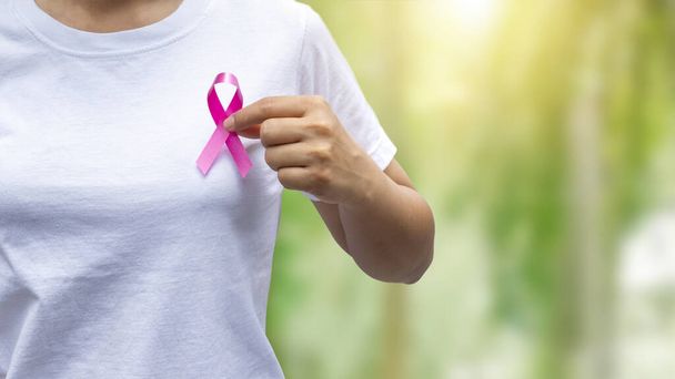 Женщины, держащие розовые ленточки, информирующие о раке груди, концепции здравоохранения и символы рака молочной железы. - Фото, изображение