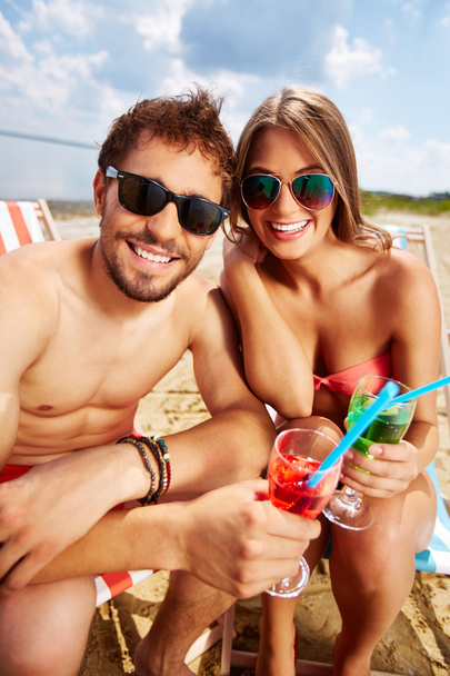 Amantes com bebidas que fazem festa na praia
 - Foto, Imagem