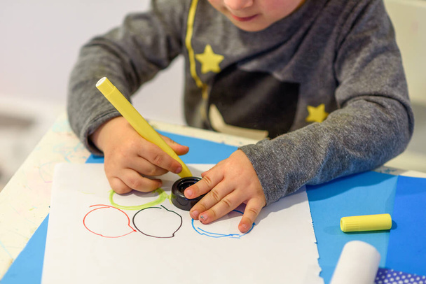Pieni lapsi lapsi maalaus laski kärki kynät värikkäitä renkaita paperille. - Valokuva, kuva
