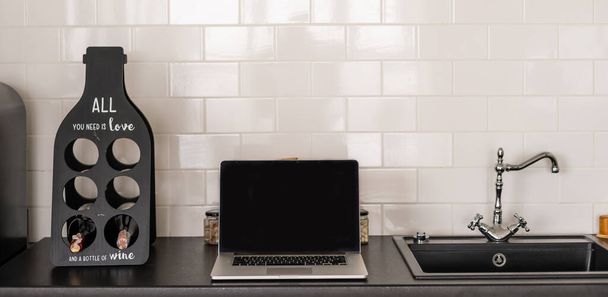 Laptop schermo bianco sul tavolo con sfondo della cucina. - Foto, immagini