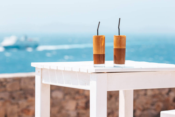 Kávové latté na dřevěném stole s mořským pozadím - Fotografie, Obrázek