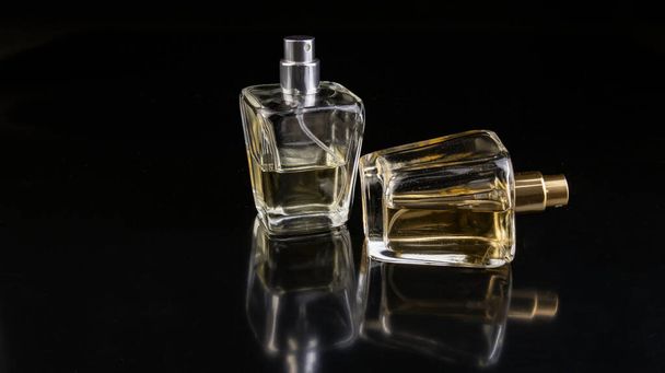 zwei Flaschen Duftessenzen auf schwarzem Hintergrund, isoliert - Foto, Bild