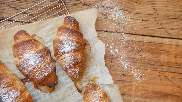 Francouzské čerstvé křupavé croissanty na dřevěném stole pohled shora - Fotografie, Obrázek
