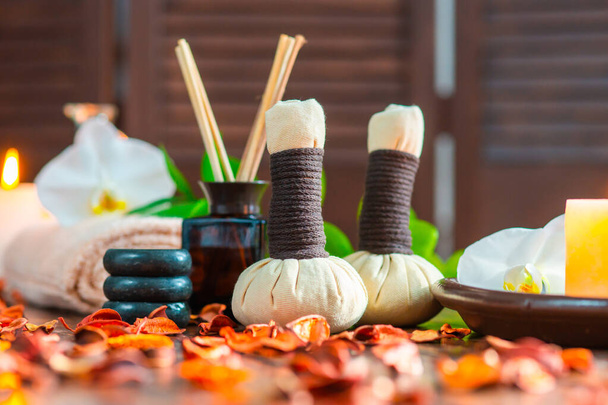 Spa background. Towel, candles, flowers, aroma sticks, massaging stones and herbal balls. Massage, oriental therapy, wellbeing and meditation concept. - Photo, Image