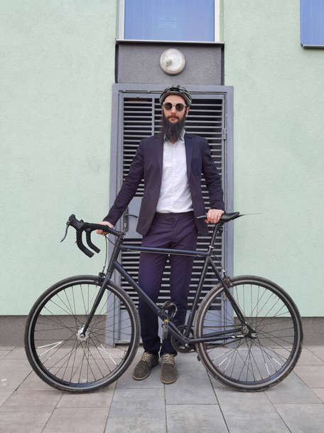 A young stylish hipster posing next to his bicycle. - Foto, afbeelding