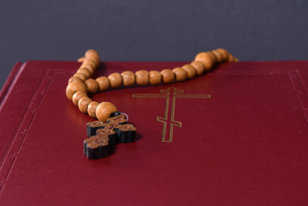 Rosario de madera con una cruz ortodoxa se encuentran en la Biblia. Fotografía de primer plano  - Foto, imagen