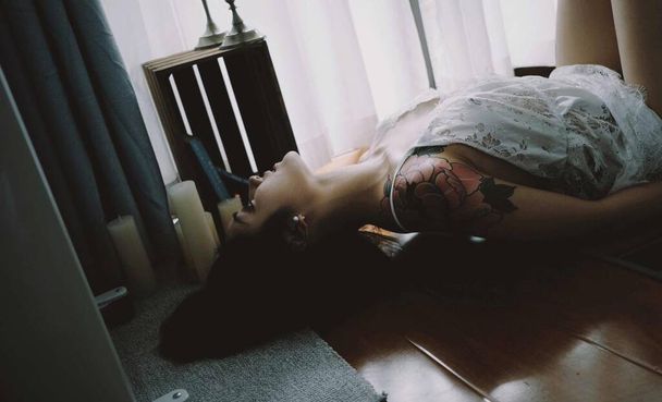 young woman lying on bed in bedroom - 写真・画像